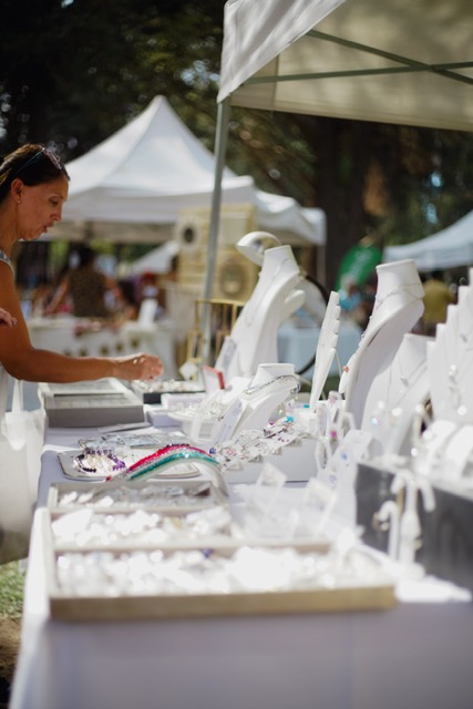 White canopy tent set up over a round table with white chairs at an outdoor event